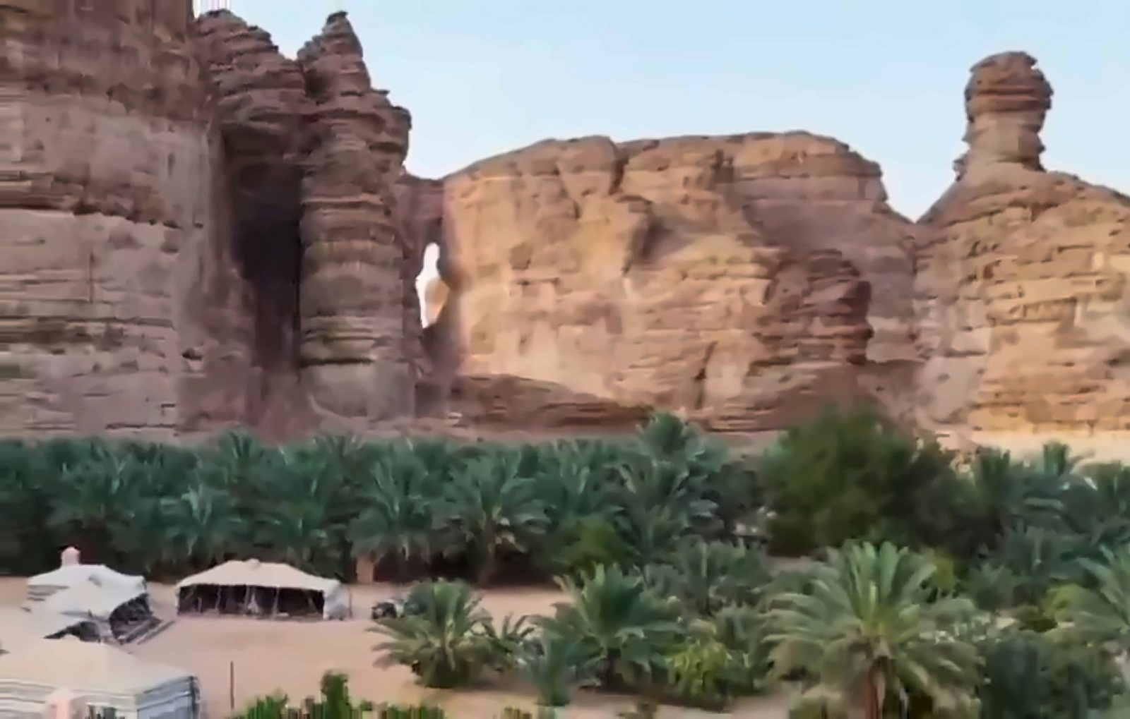 The oasis and tents beneath the cliffs